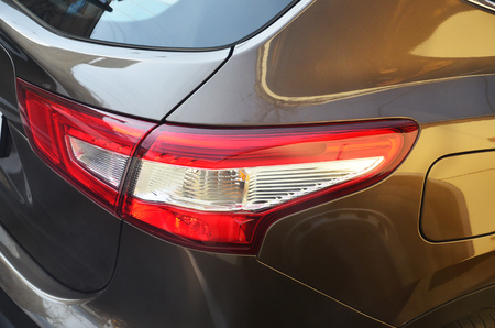 Red taillight of a brown passenger car close-up. Detailed photo of one of the car partsの写真素材