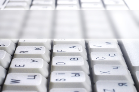 Close-up of the white computer classic keyboard with english and russian letters with copy space fieldの写真素材