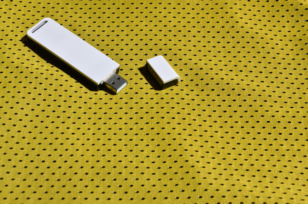 A modern portable USB adapter is placed on the yellow sportswear made of polyester nylon fiberの写真素材