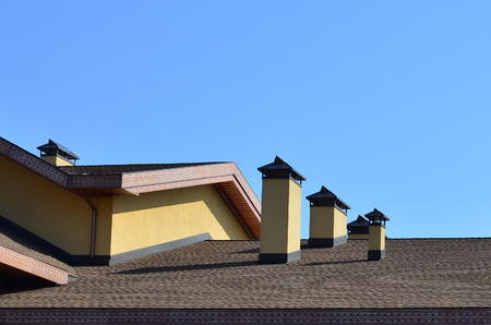Modern roofing and decoration of chimneys. Flexible bitumen or slate shingles. The absence of corrosion and condensation due to the flexible roofの写真素材