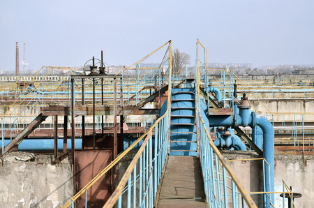 Industrial space with lots of pipes and communications on a background of blue sky. old water...