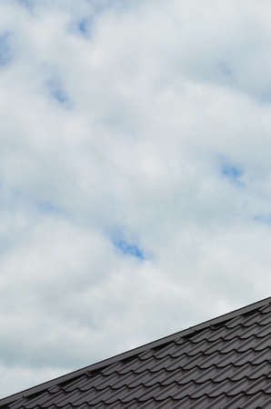 Brown roof tiles or shingles on house as background image. New overlapping brown classic style roofing material texture pattern on a actual houseの写真素材
