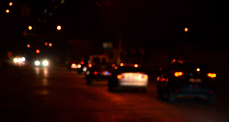 Nights lights of the big city, the blurred night avenue with bokeh traffic lights and headlights of the approaching carsの写真素材