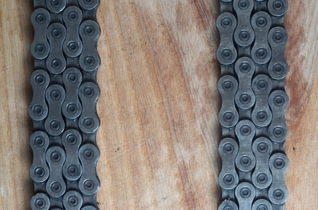 Dirty and oily chain from a mountain bike lying on a wooden table in a bicycle shop. One of the main elements of the transmission of torque on bikes and bicycles close upの写真素材