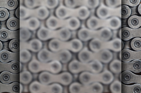 Background image of a chain from a mountain bike lying on a wooden table in a bicycle shop. One of the main elements of the transmission of torque on bikes and bicycles of various typesの写真素材