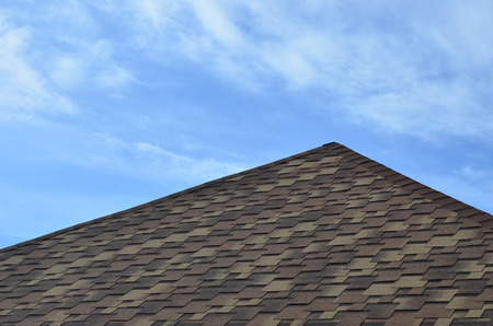 The roof of a residential house, covered with a modern flat bituminous waterproof coating under a...