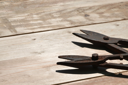A few rusty scissors for metal on a wooden background. Obsolete household tools made of rusty metal...