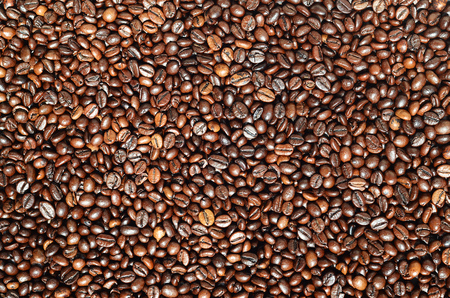 Background texture of a huge number of fragrant and fresh brown roasted coffee grains. One of the stages of making natural coffeeの写真素材