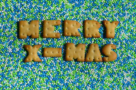 Merry X-Mas. The word from the edible cracker letters lies on the glazed powder. A huge number of sweet, colorful 
beads of very small size for decoration of pastry productsの写真素材