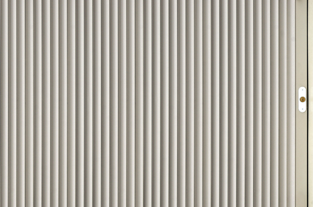The texture of the shutter door or window in light gray color. Metal gates or shutters for garage or shop, metal sheet texture, steel rolling shutterの写真素材