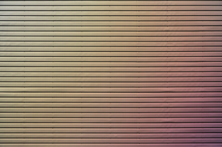 The texture of the wall is made of metal coating of huge aluminum plates of relief shape with horizontal notches. A variety of metal siding close-upの写真素材
