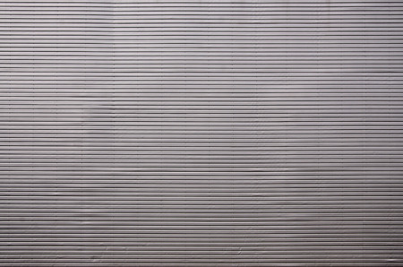 The texture of the wall is made of metal coating of huge aluminum plates of relief shape with horizontal notches. A variety of metal siding close-upの写真素材