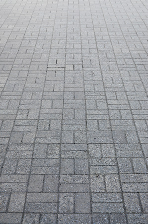 Photo of the site from the old paving slab with small defects and cracks, leaving in perspective. Street coverage of pedestrian areas and paths in parks in daylight outdoorsの写真素材