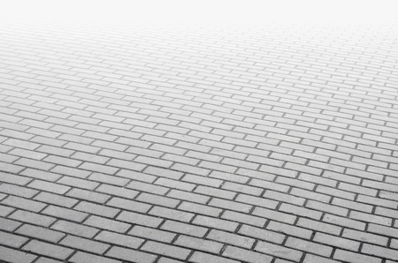 Photo of the site from the old paving slab with small defects and cracks, leaving in perspective. Street coverage of pedestrian areas and paths in parks in daylight outdoorsの写真素材