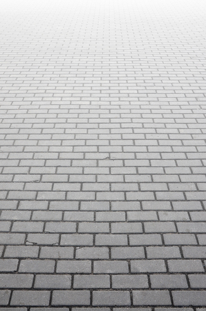 Photo of the site from the old paving slab with small defects and cracks, leaving in perspective. Street coverage of pedestrian areas and paths in parks in daylight outdoorsの写真素材
