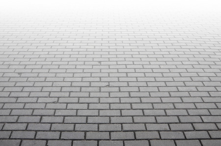 Photo of the site from the old paving slab with small defects and cracks, leaving in perspective. Street coverage of pedestrian areas and paths in parks in daylight outdoorsの写真素材