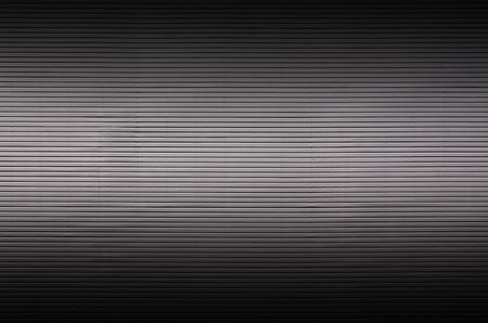 The texture of a metal wall or a surface of corrugated metal with invisible light sources that illuminate the middle of the platform for product placementの写真素材