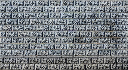Weathered stained old block wall background. Texture of an old wall of several floors with lots of rows of blocksの写真素材
