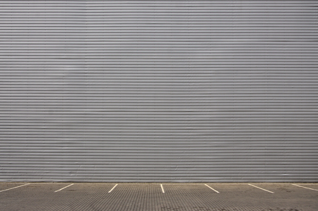 Empty parking spaces on the background of a metal wall with plenty of free space for product placement related to mechanics and carsの写真素材