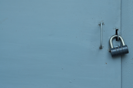 The texture of the metal surface from the outer old door with a black padlockの写真素材