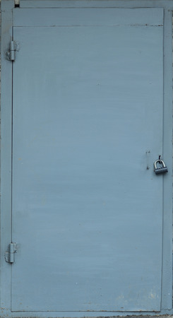 The texture of the metal surface from the outer old door with a black padlockの写真素材