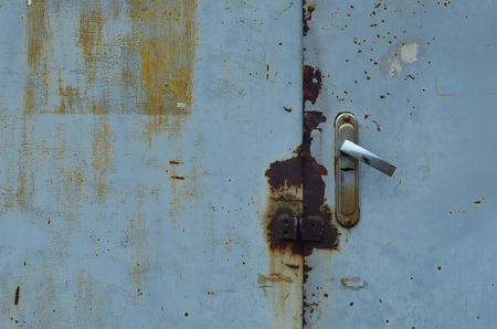 The texture of the metal surface from the outer old door with a standard door lockの写真素材