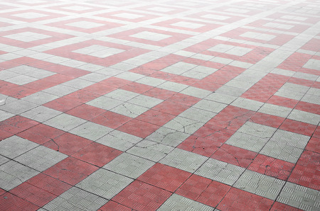Photo of the site from the old paving slab with small defects and cracks, leaving in perspective....