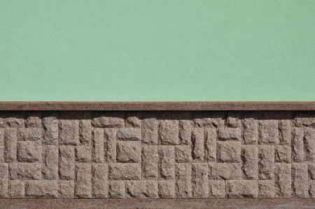 The horizontal texture of the foundation in the form of a mosaic made of a dark, coarse and strong granite stone in the sunlight outdoorsの写真素材