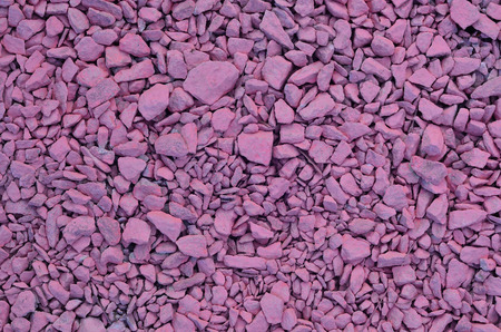 Texture from a pile of crushed stone, painted in light pink color. Background image of many pink stones of different shapes and sizesの写真素材