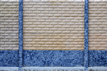 Stone fence texture - building feature. The texture of a modern concrete fence in the form of neat brickworkの写真素材