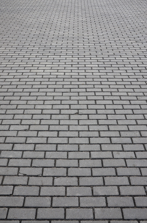 Photo of the site from the old paving slab with small defects and cracks, leaving in perspective. Street coverage of pedestrian areas and paths in parks in daylight outdoorsの写真素材