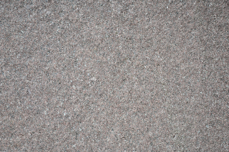 Monochromatic texture of granite surface. Detailed photo of the treated glossy granite stone, which is used as tiles for walls and floorsの写真素材
