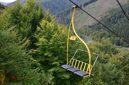The seats of the cable car on the background of Mount Makovitsa, one of the Carpathian Mountainsの写真素材