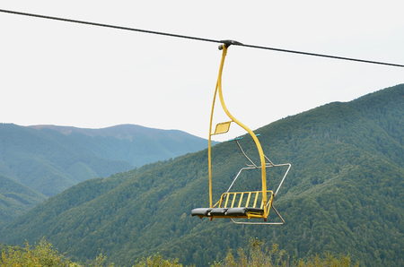 The seats of the cable car on the background of Mount Makovitsa, one of the Carpathian Mountainsの写真素材