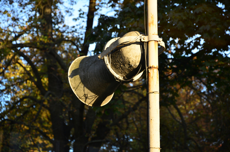 The old horn with the peeling paint is installed on the pillar. Device for the transmission of oral informationの写真素材