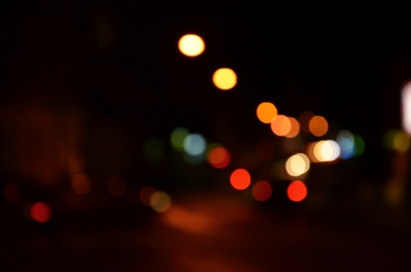 Blurred night scene of traffic on the roadway. Defocused image of cars traveling with luminous headlights. Bokeh Artの写真素材