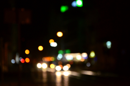 Blurred night scene of traffic on the roadway. Defocused image of cars traveling with luminous headlights. Bokeh Artの写真素材