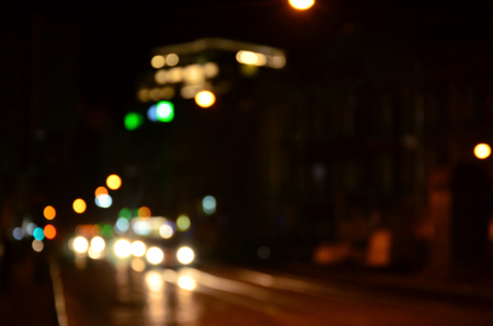 Blurred night scene of traffic on the roadway. Defocused image of cars traveling with luminous headlights. Bokeh Artの写真素材