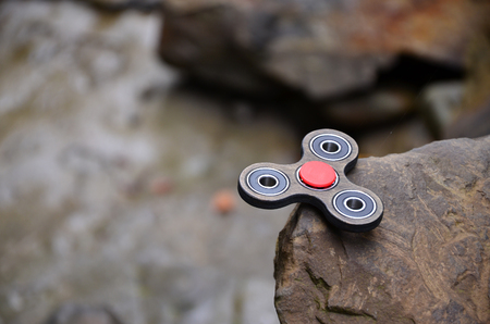 The wooden spinner lies on the rocks against the background of a small waterfall and a riverの写真素材