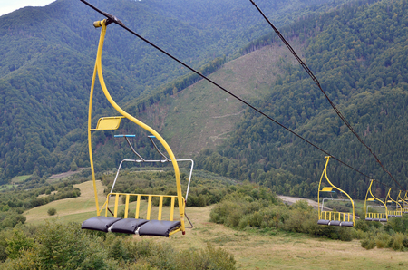 The seats of the cable car on the background of Mount Makovitsa, one of the Carpathian Mountainsの写真素材