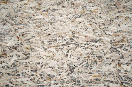 An old oriented strand board (OSB), fiberboard background of texture. Sheet is made of brown wood chips pressed together into a wooden floorの写真素材