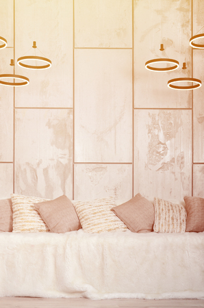 Many pillows lie on the couch, which is covered with a large plush veil against the background of a marble wallの写真素材