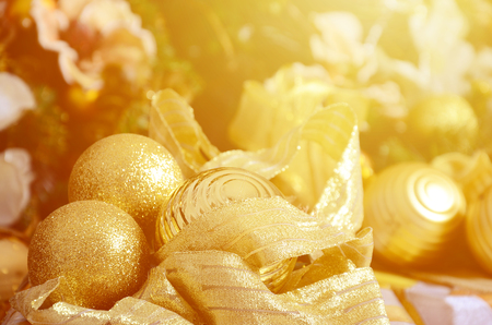 Photo of luxury gift boxes under Christmas tree, New Year home decorations, golden wrapping of Santa presents, festive fir tree decorated with garland, baubles and toys, traditional celebrationの写真素材