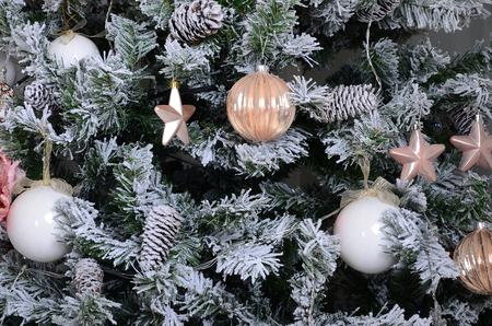 Decorating Christmas tree close up. Decoration bulb, snowy green fir tree, pink x-mas toys and lights. Use for Christmas and New years celebration backgroundの写真素材