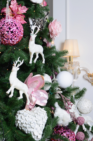 Decorating Christmas tree close up. Decoration bulb, fir tree, pink x-mas toys and lights. Use for Christmas and New years celebration backgroundの写真素材