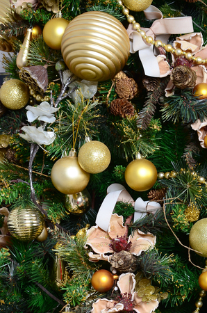 Decorating Christmas tree close up. Decoration bulb, green fir tree, golden x-mas toys and lights. Use for Christmas and New years celebration backgroundの写真素材