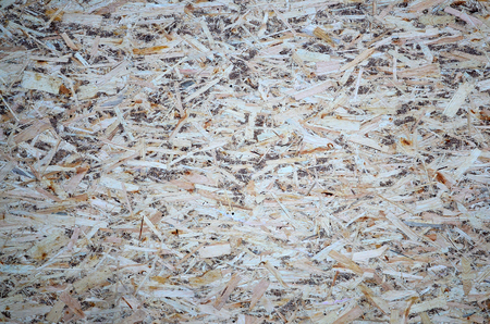 An old oriented strand board (OSB), fiberboard background of texture. Sheet is made of brown wood chips pressed together into a wooden floorの写真素材