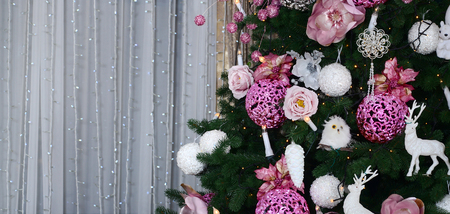 Decorating Christmas tree close up. Decoration bulb, fir tree, pink x-mas toys and lights. Use for Christmas and New years celebration backgroundの写真素材