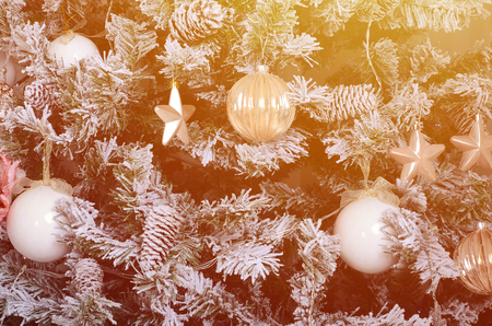 Decorating Christmas tree close up. Decoration bulb, snowy green fir tree, pink x-mas toys and lights. Use for Christmas and New years celebration backgroundの写真素材