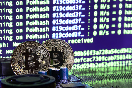 The digital process of cryptocurrency mining by using the GPUs. Bitcoins and video card on a working display and mining screenの写真素材